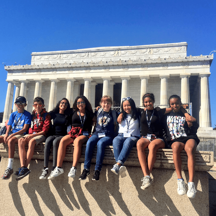 Middle school students posing on sunny day in front of Lincoln Memorial